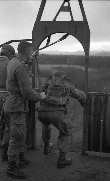     Le parachutiste en position montre bien le parachute dorsal d'instruction dont il est équipé